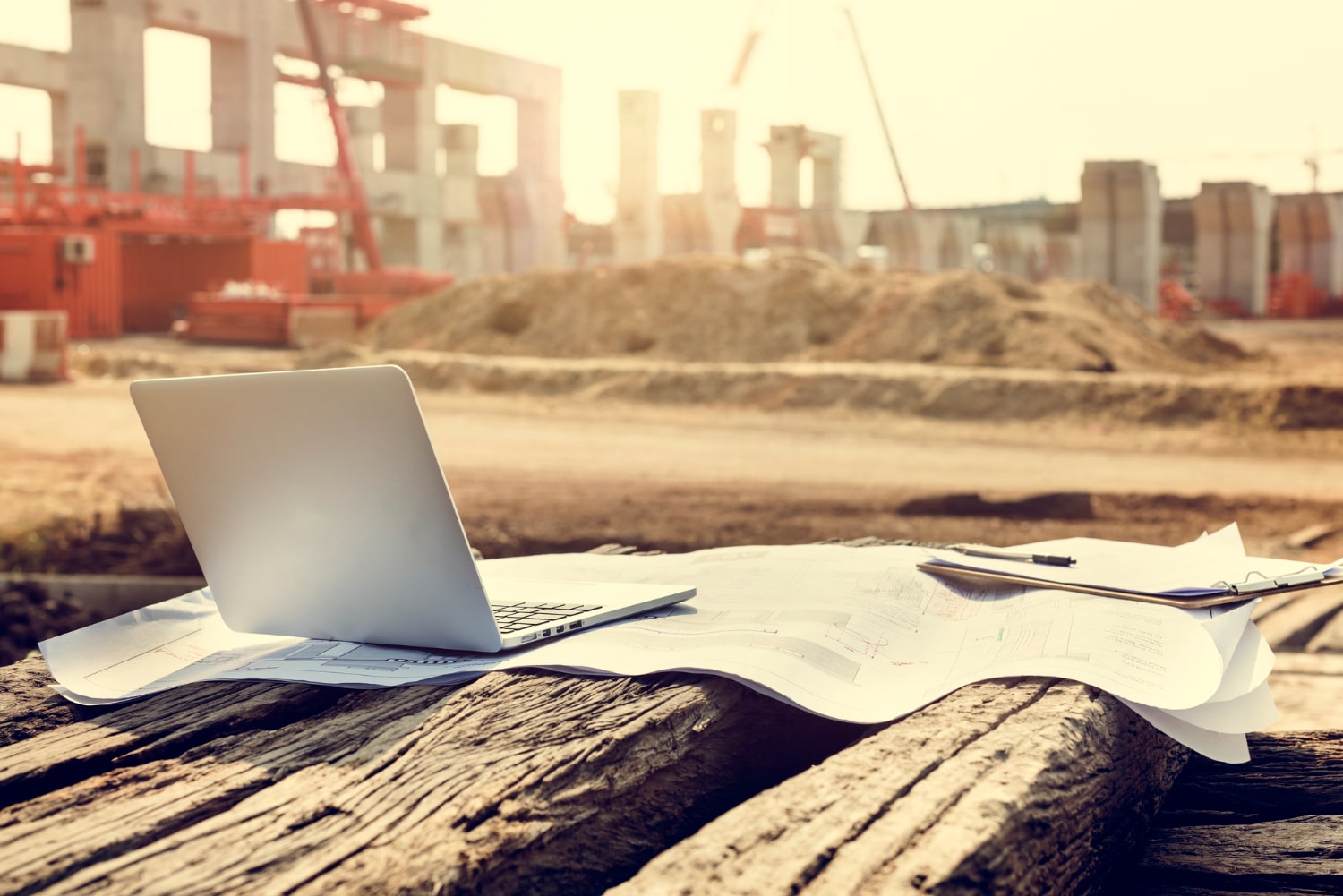 Laptop and construction plans on site at a London building project, representing the work of local contractors.