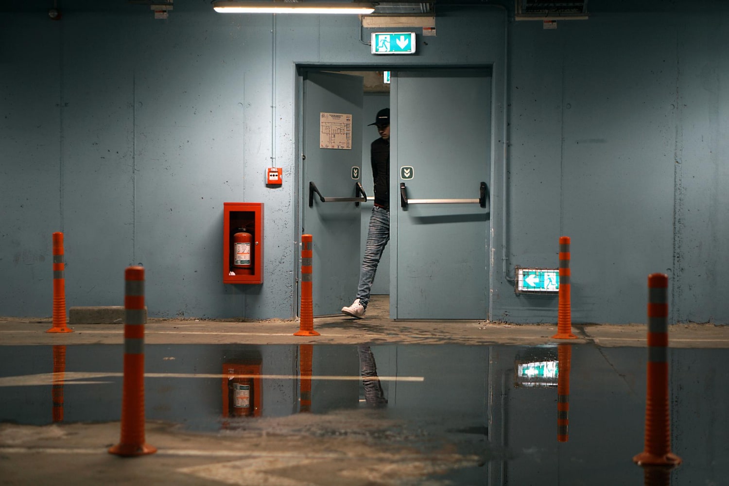 Emergency fire doors in an underground car park with a person exiting, reflecting the safety standards associated with Fire Doors UK.